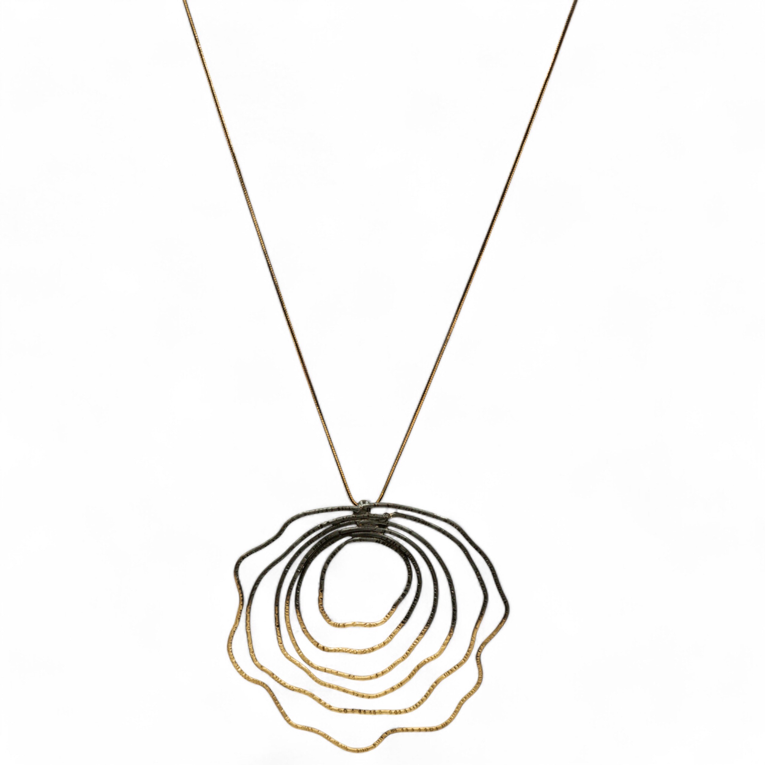 Μακρύ χειροποίητο κολιέ με κυματιστό σχέδιο από πολλαπλούς ομόκεντρους κύκλους. Κατασκευασμένο από ορείχαλκο, διαθέσιμο σε επιχρυσωμένο, μαύρη οξείδωση και free nickel φινίρισμα. Ιδανικό για statement εμφανίσεις. Μήκος 80cm.