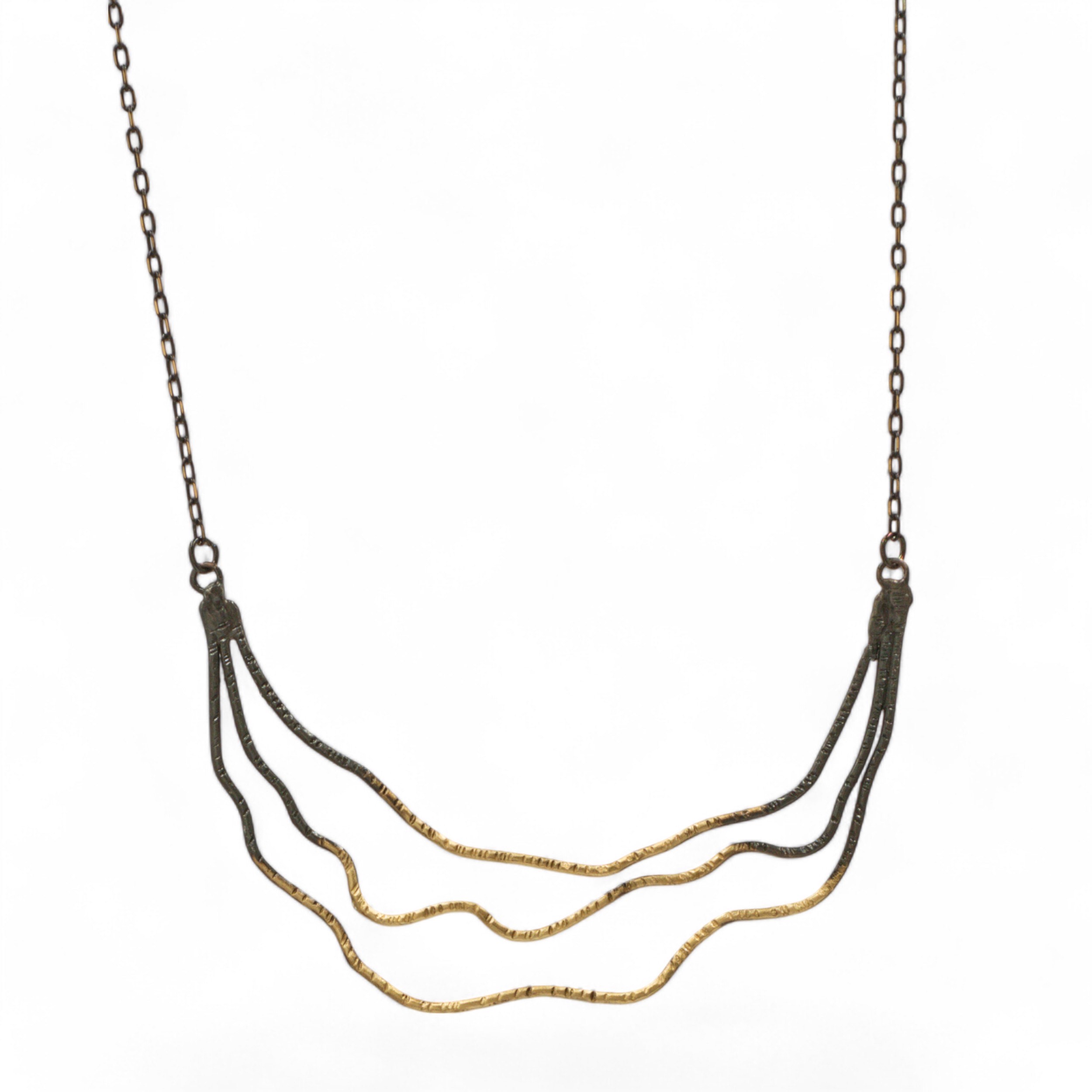 Κοντό χειροποίητο κολιέ με τρία κυματιστά σύρματα ορείχαλκου σε διαφορετικά φινιρίσματα: επίχρυσο, μαύρη οξείδωση και free nickel. Ελαφρύ, εντυπωσιακό και μίνιμαλ σχέδιο. Μήκος 45cm.